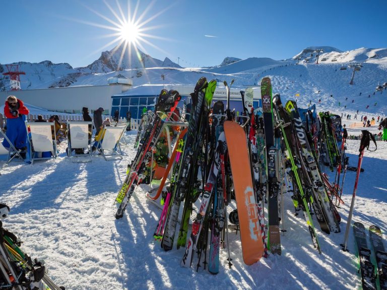 Bellavista-Brand_Skigebiet Skiausrüstung steht in sonnigen Skigebiet Brandnertal, Österreich im Schnee. Berge im Hintergrund.